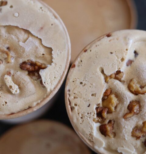 Coffee Ice-cream in brown cardboard containers. They have walnut pieces mixed in.