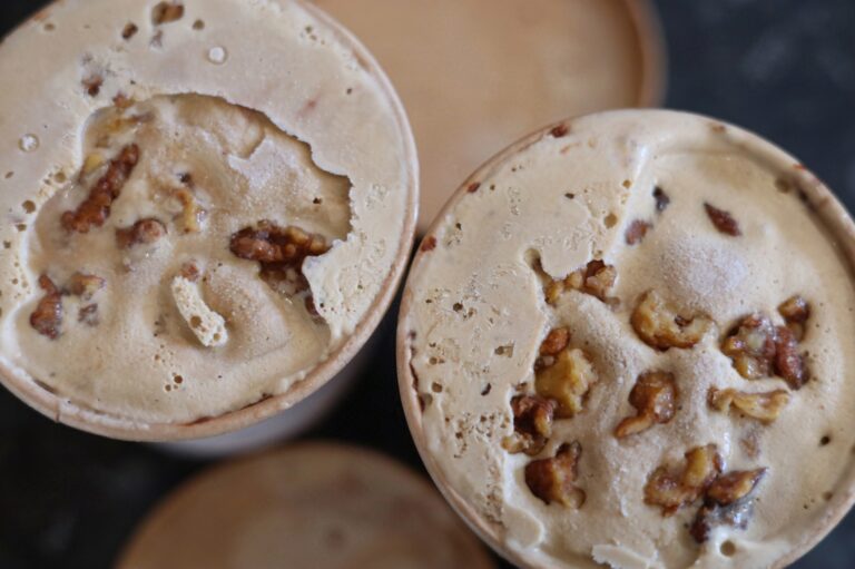 Coffee Ice-cream in brown cardboard containers. They have walnut pieces mixed in.
