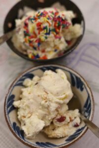 Two bowls of classic Tutti Frutti Ice Cream. One has sprinkles and one does not. 